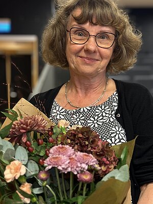 Barbara Törnquist Plewa med blommor efter sin Rausngflöreläsning