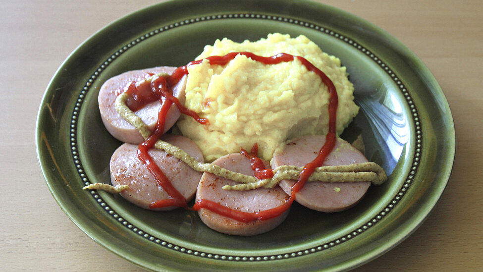 Falukorv med potatismos, ketchup och senap. Upplagt på grön70-talstallrik.