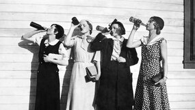 Svartvitbild. Fyra kvinnor på rad står och dricker ur flaskor samtidgt.från Källa: Library of Congress, USA 