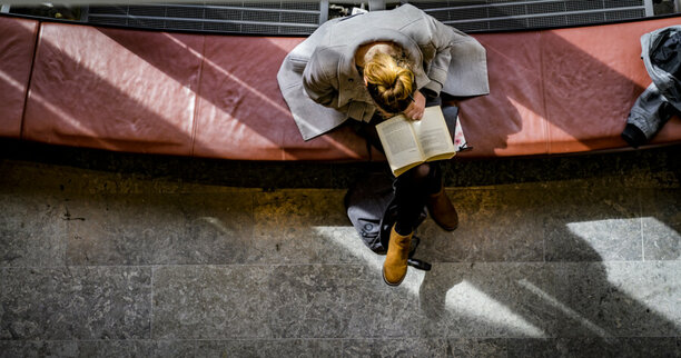 En kvinna läser i en bok.