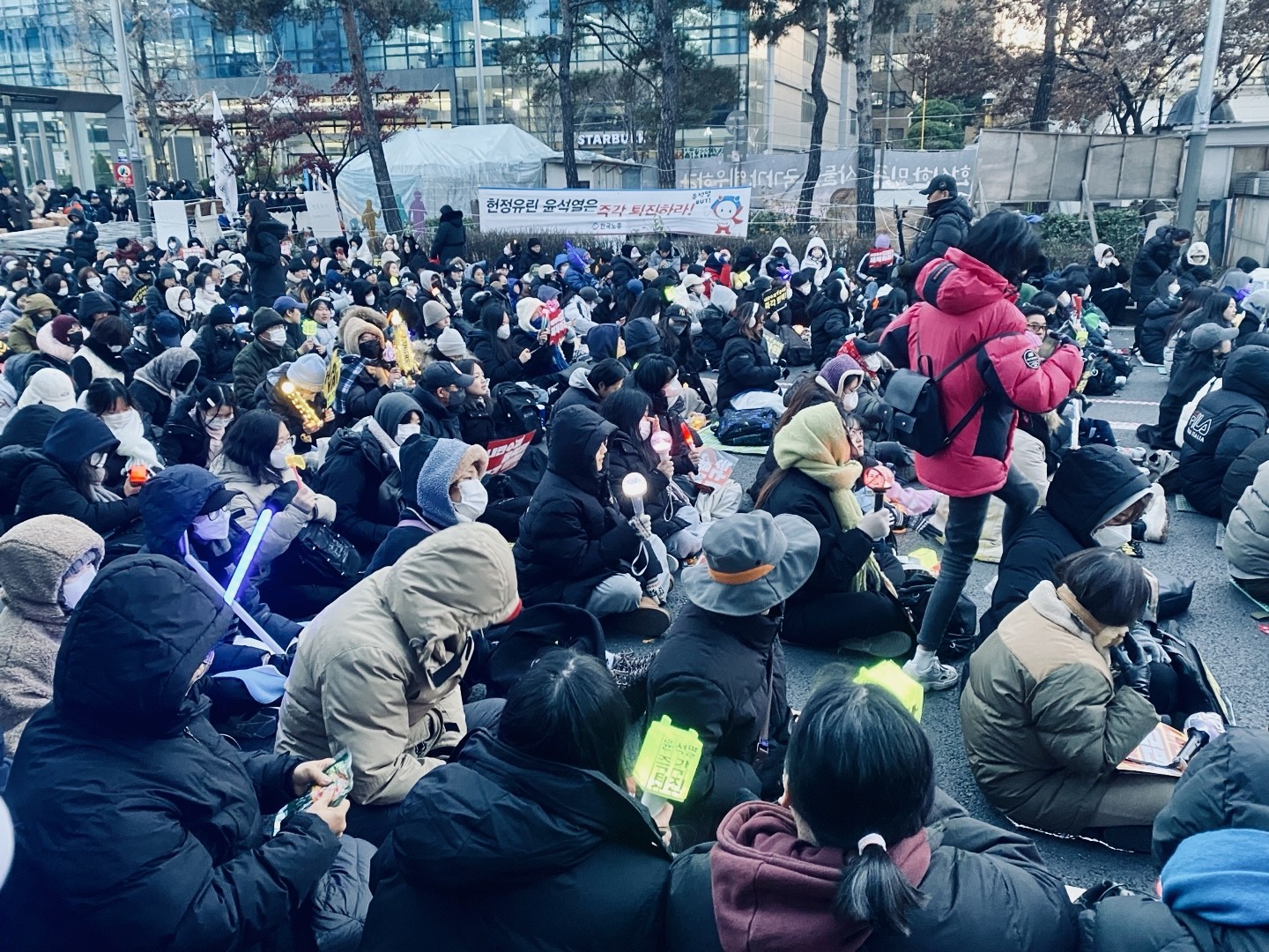 South Korean protesters holding K-pop nightsticks and placards during a rally demanding Yoon’s impeachment. Photo by Minyoung Kim.